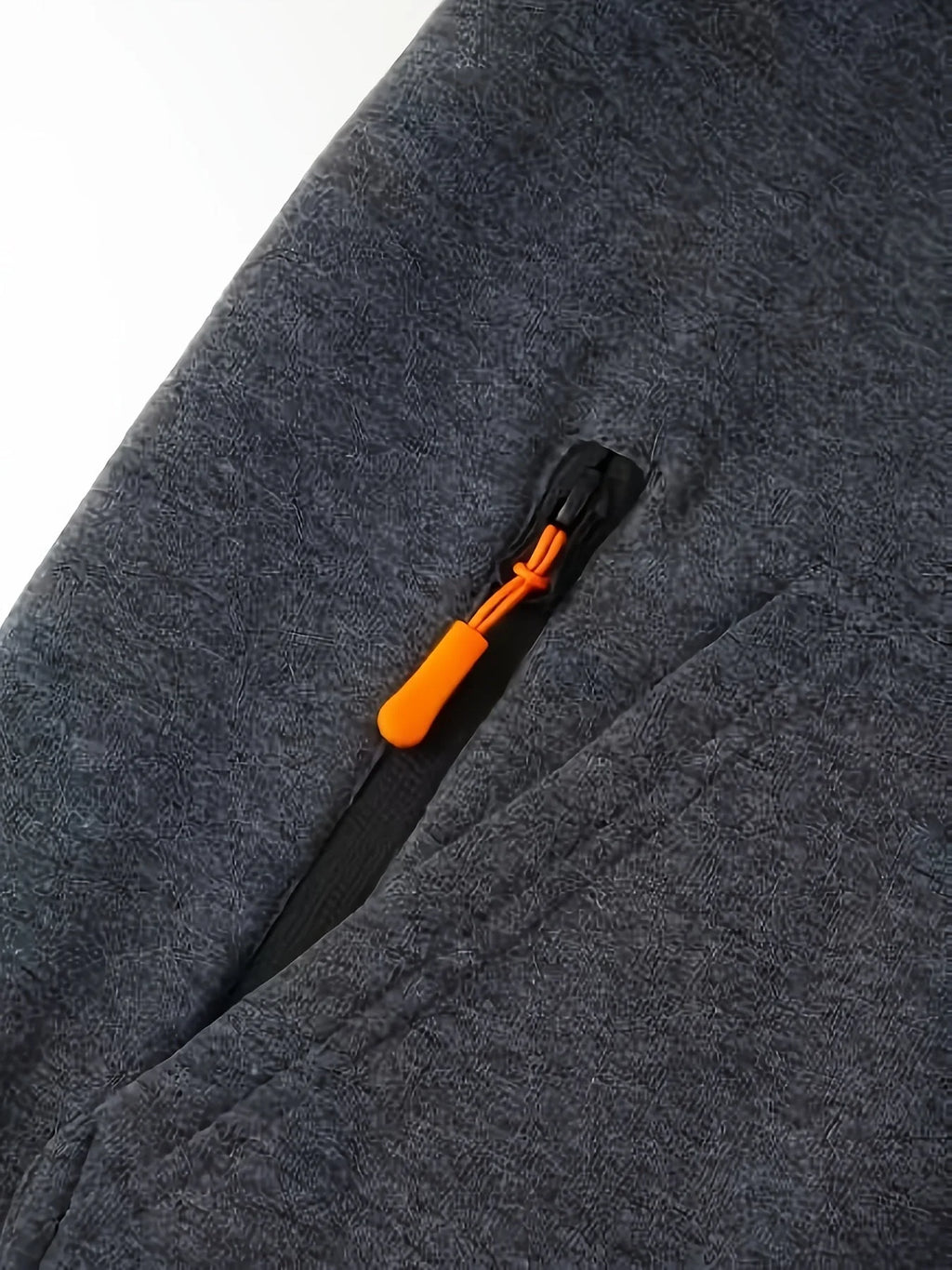 Close-up of sleeve zip pocket with orange zip pull on grey fleece fabric