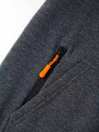 Close-up of sleeve zip pocket with orange zip pull on grey fleece fabric