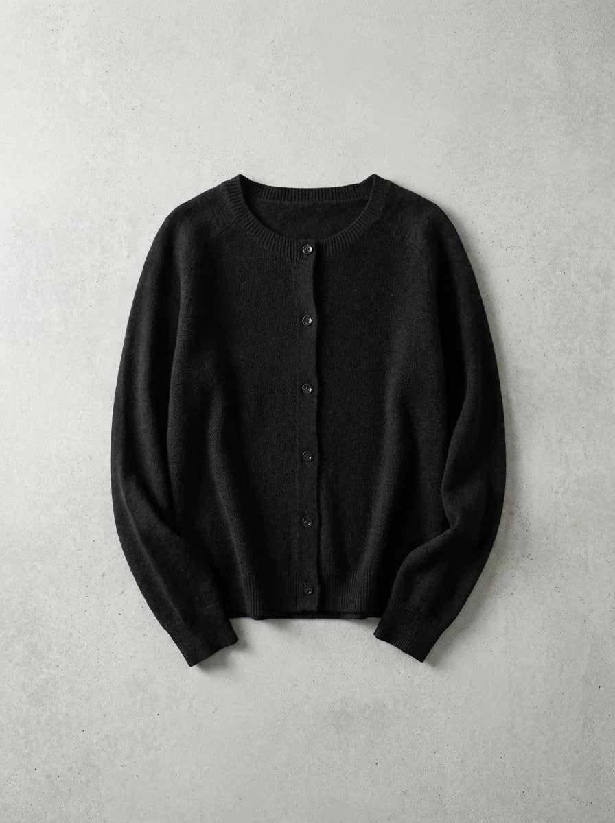 Black knitted cardigan with crew neck and front buttons, photographed flat on a plain grey backdrop