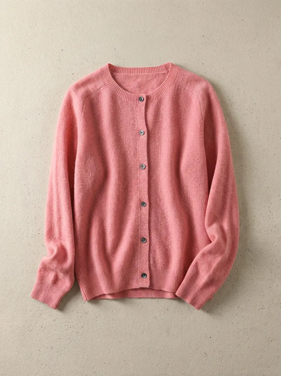 Coral pink cardigan with round neck and tortoiseshell buttons, shown flat on a soft grey background
