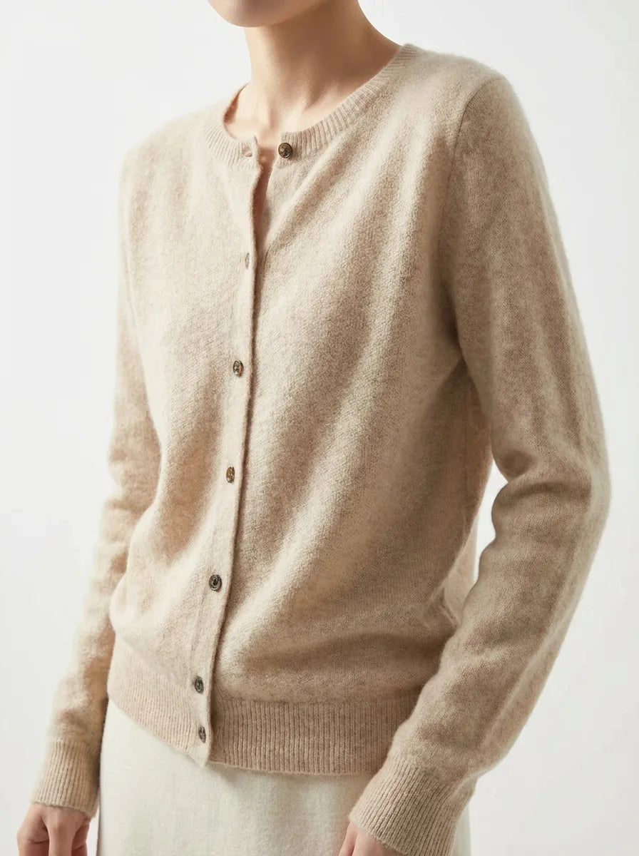 Close-up of a beige knitted cardigan with tortoiseshell buttons, paired with a cream skirt