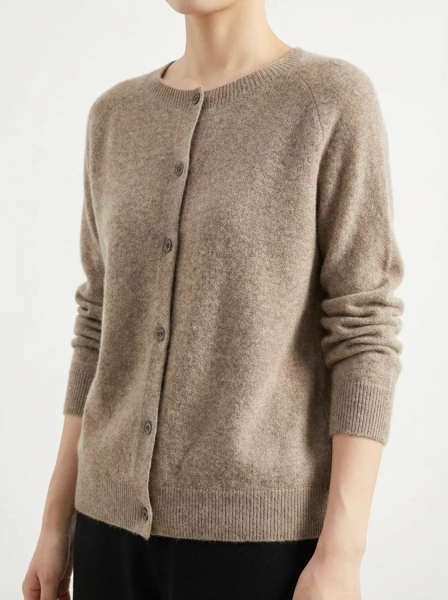 Detail shot of a knitted cardigan's button placket and ribbed cuff showing the fabric's soft texture