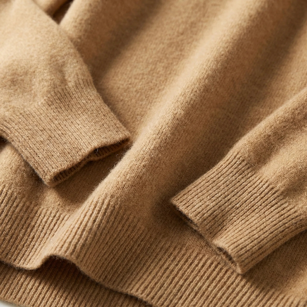 Folded emerald green merino wool jumper showing the dropped shoulder seam and long sleeve fit