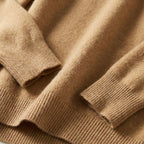 Folded emerald green merino wool jumper showing the dropped shoulder seam and long sleeve fit