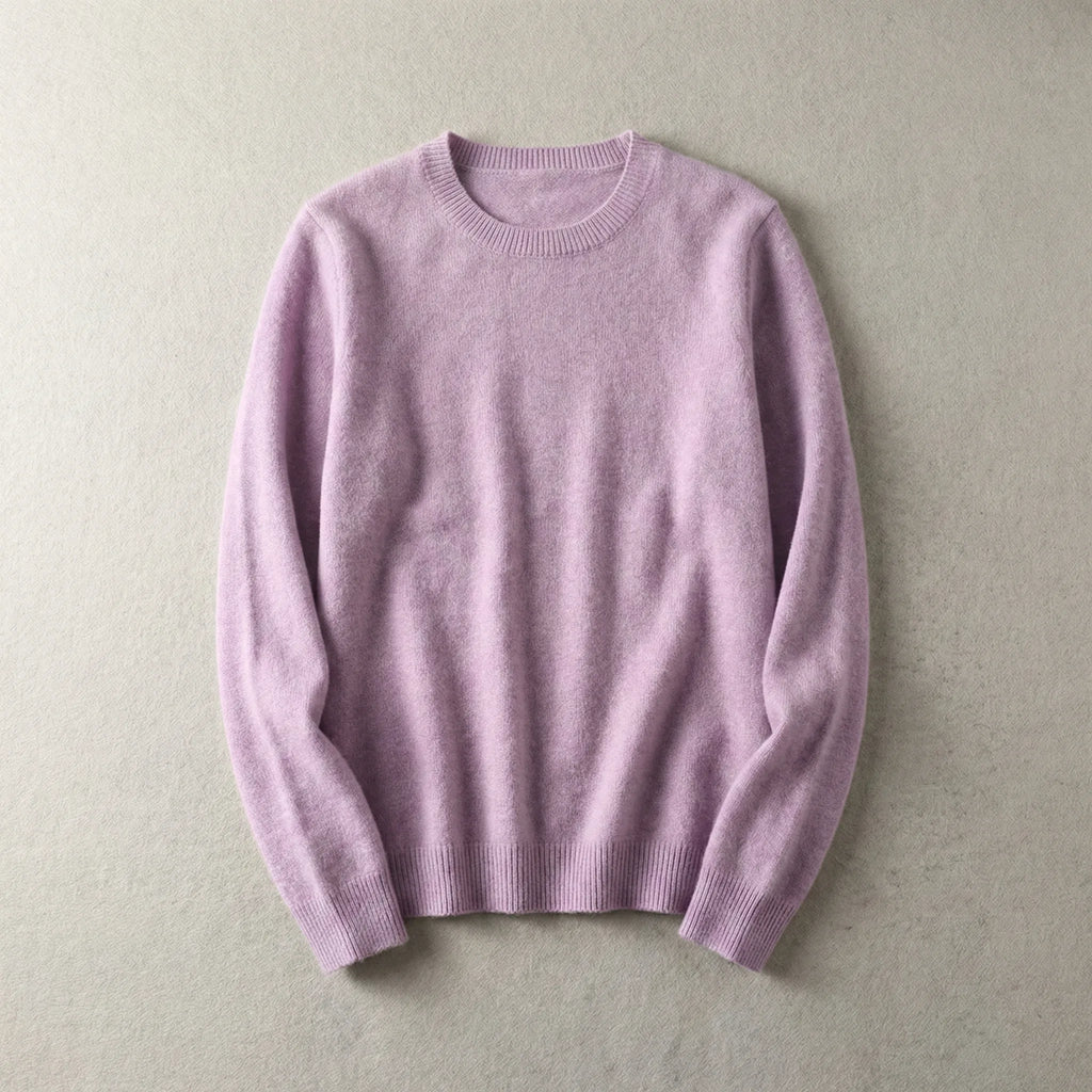 Folded lilac pink merino wool jumper with ribbed hem and neckline, laid flat on a pale backdrop