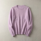 Folded lilac pink merino wool jumper with ribbed hem and neckline, laid flat on a pale backdrop