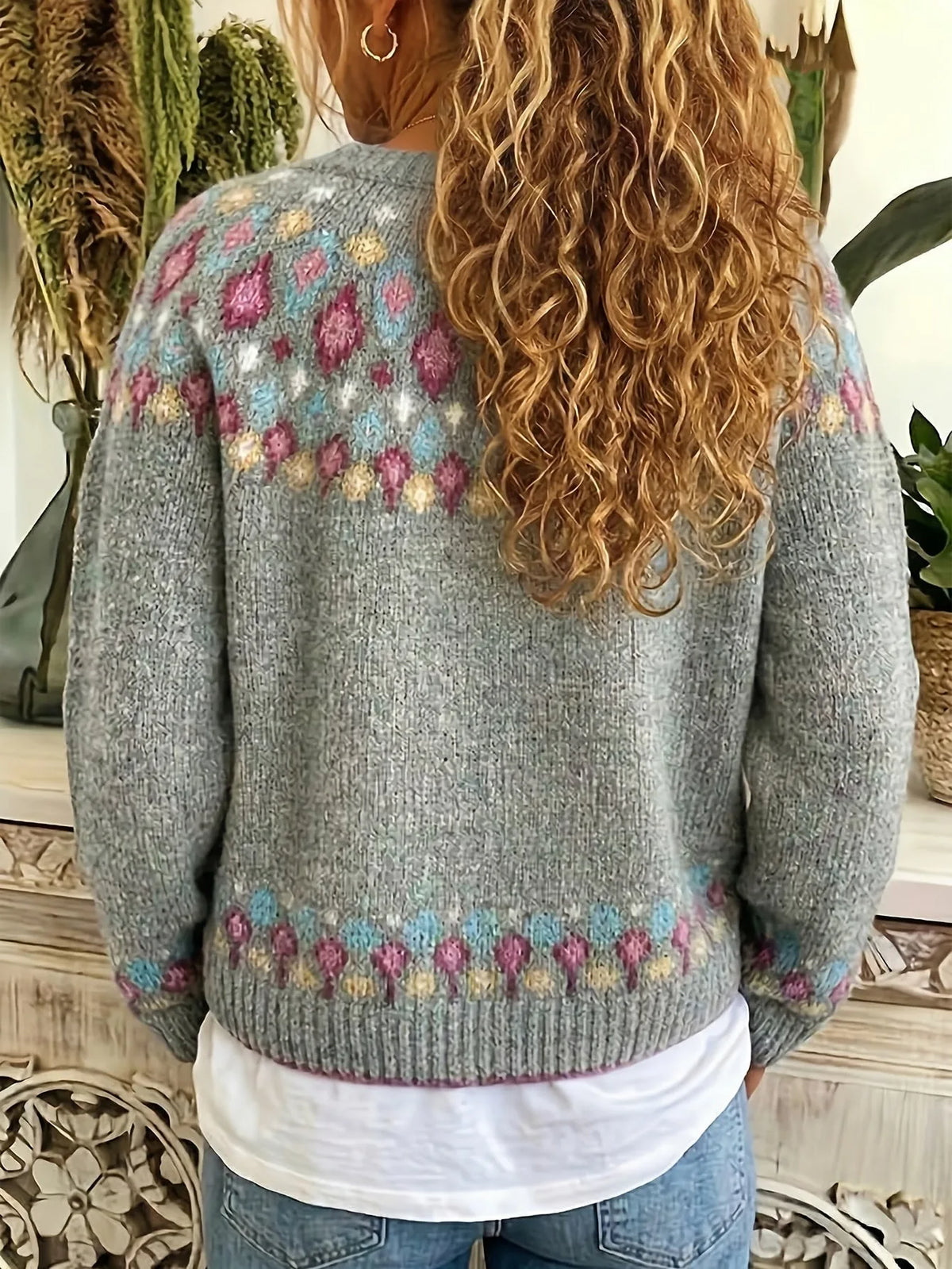 Back view of a model wearing the grey cardigan, showing the Fair Isle shoulder pattern and ribbed hem detail