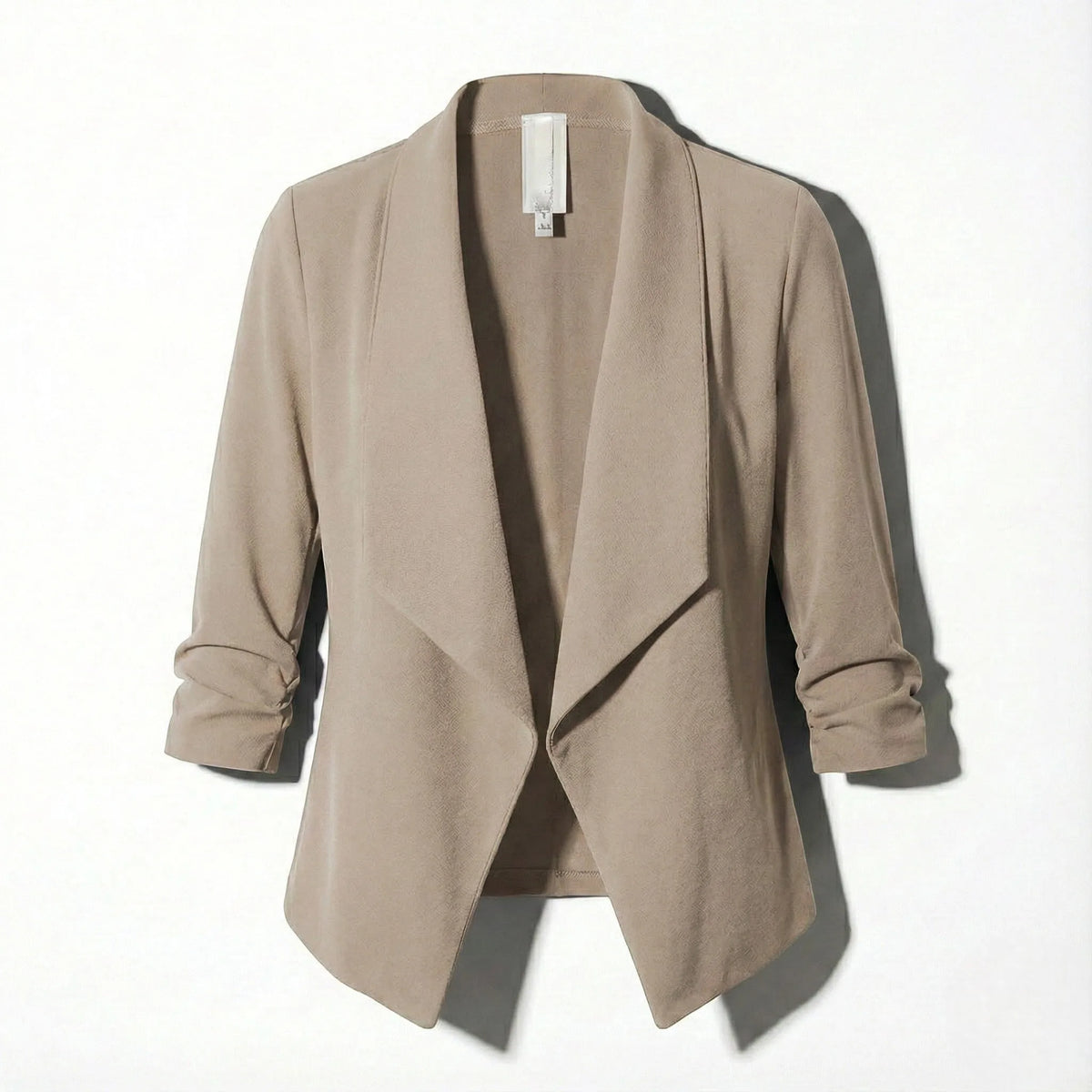 Beige open-front blazer laid flat, showing the draped lapel and soft textured fabric
