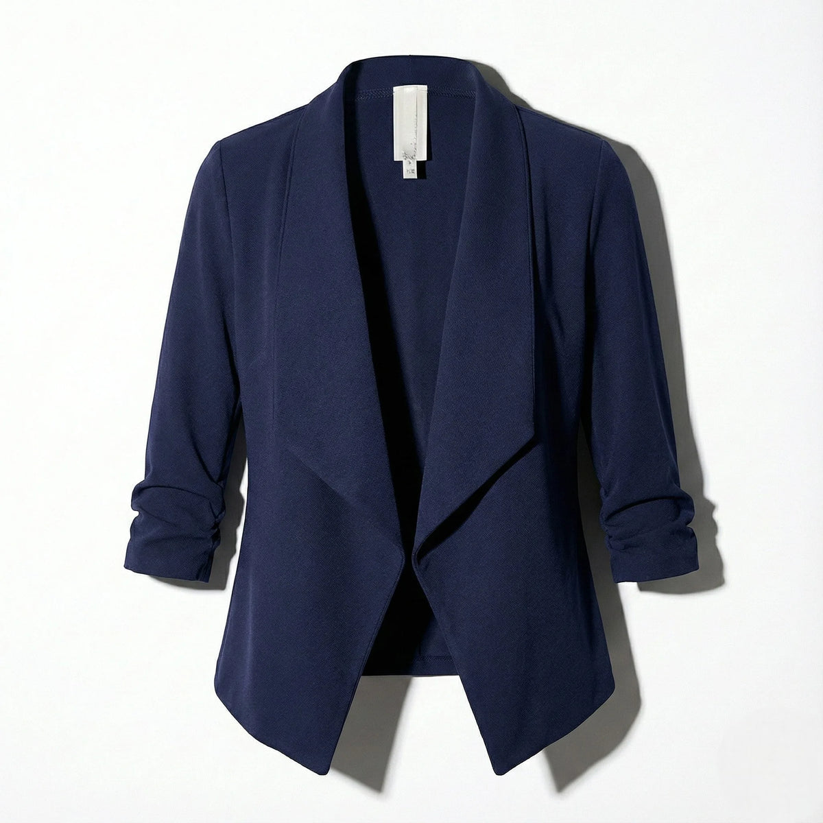 Navy open-front blazer laid flat, showing the structured silhouette and gathered cuffs