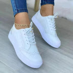 White leather brogue-style lace-up trainers with tan trim and white platform sole
