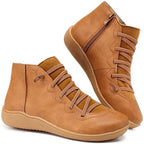 Side view of tan brown ankle boots with crisscross elastic lace detail and front zip fastening