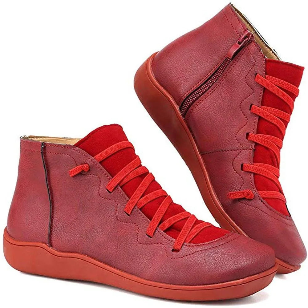 Pair of red ankle boots showing scalloped panel stitching and matching red sole