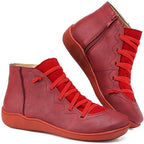 Pair of red ankle boots showing scalloped panel stitching and matching red sole