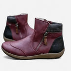 Burgundy leather ankle boots with side zip pull and thick tan outsole, side profile