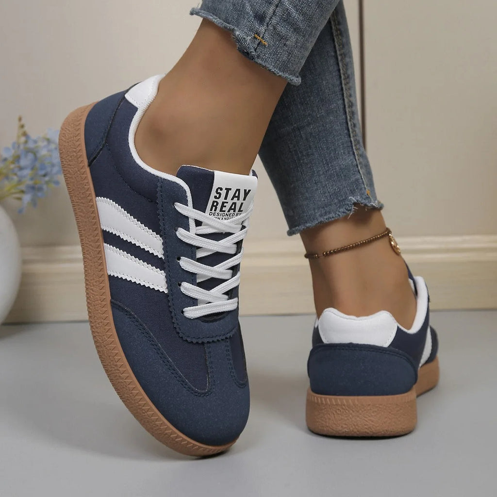 Off-white trainer with black stripes and suede panels, cream insole with tongue label visible