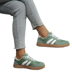 Off-white trainer with black stripes held in hand, side profile with gum sole detail