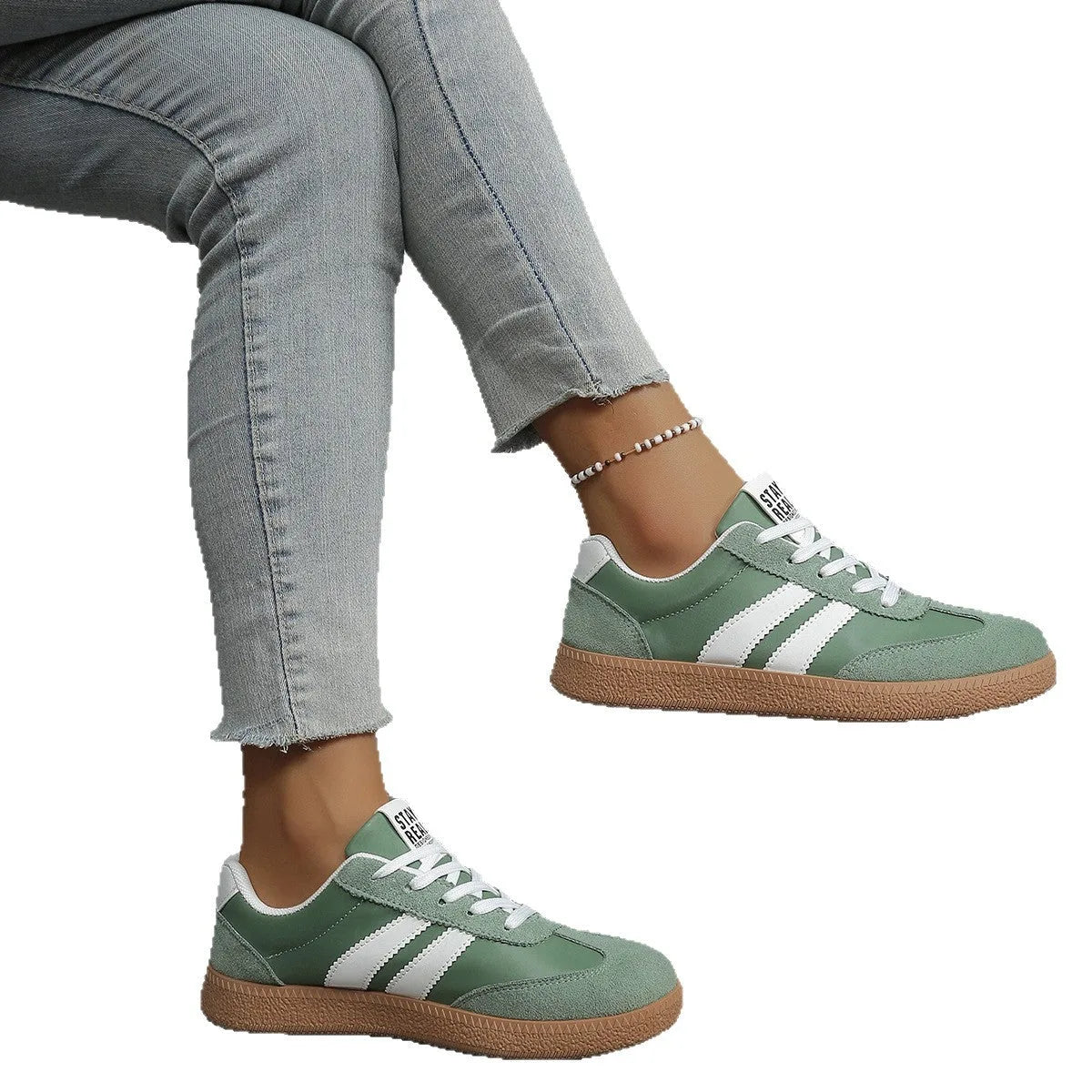 Off-white trainer with black stripes held in hand, side profile with gum sole detail