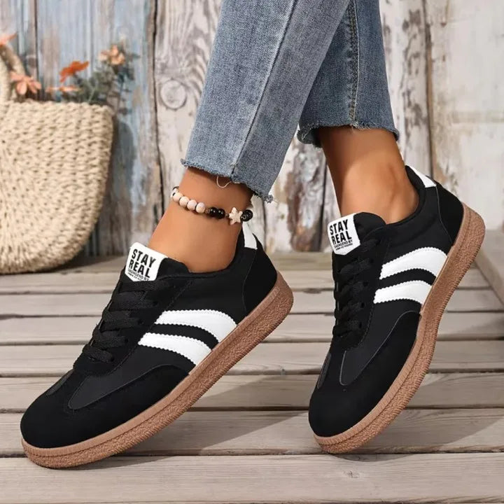 Navy trainer close-up on ankle showing white heel panel and lace detailing