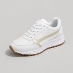 Studio shot of a single white trainer with cream panelling, white laces and a gum-tone chunky sole on a plain background