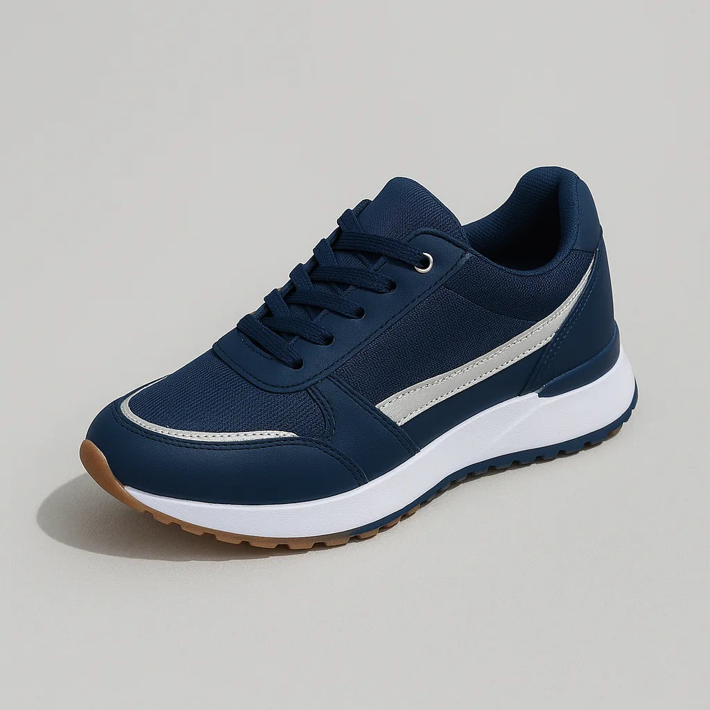 Studio shot of a single navy trainer with a silver side stripe, navy laces and a white chunky sole on grey background