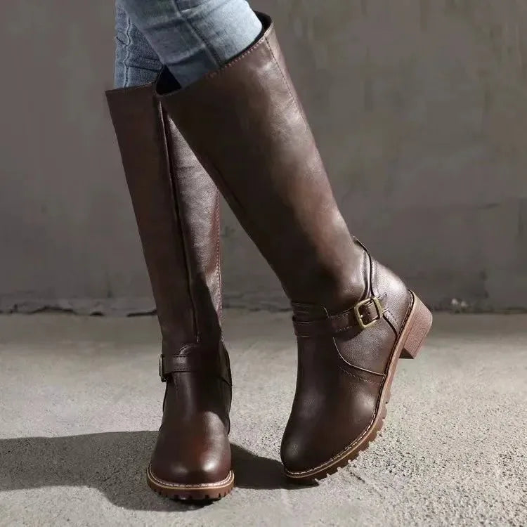 Close-up side angle of dark brown knee-high boot highlighting buckle strap and stitched leather panel
