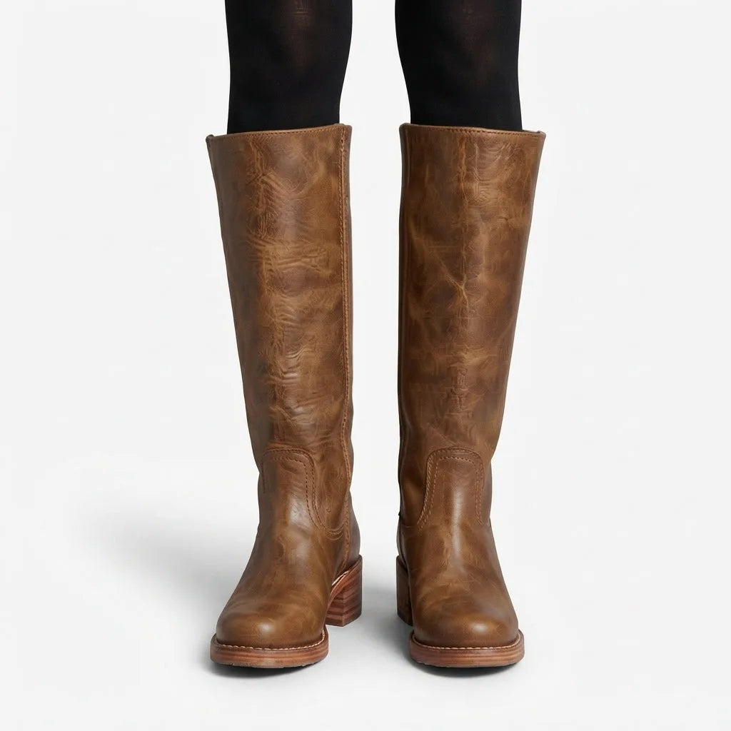 Front view of light brown weathered leather knee high boots worn with black tights, showing creased texture