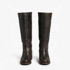 Front view of dark brown leather knee high boots side by side, showing stitched panel detail at the ankle