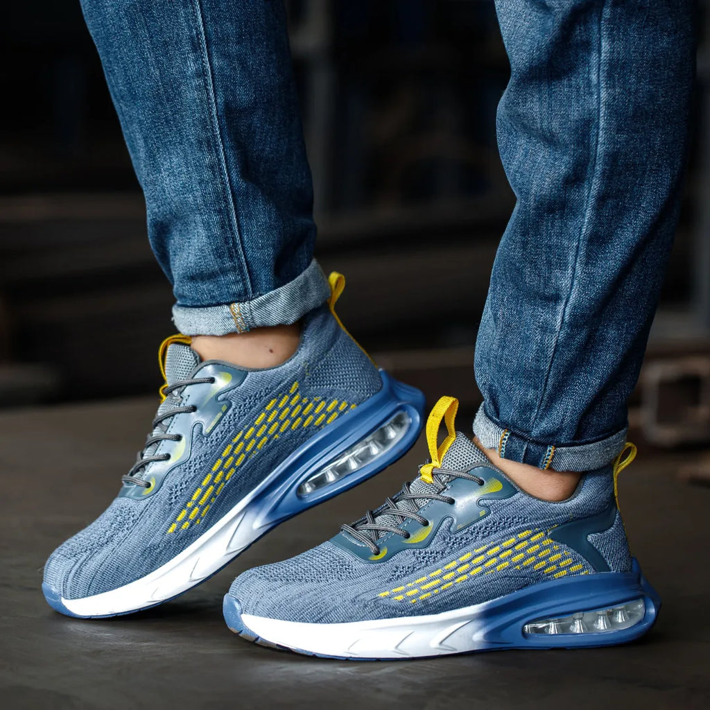 Front angled view of both blue trainers worn with rolled jeans, showing white midsole and air cushion heel unit