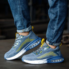 Front angled view of both blue trainers worn with rolled jeans, showing white midsole and air cushion heel unit