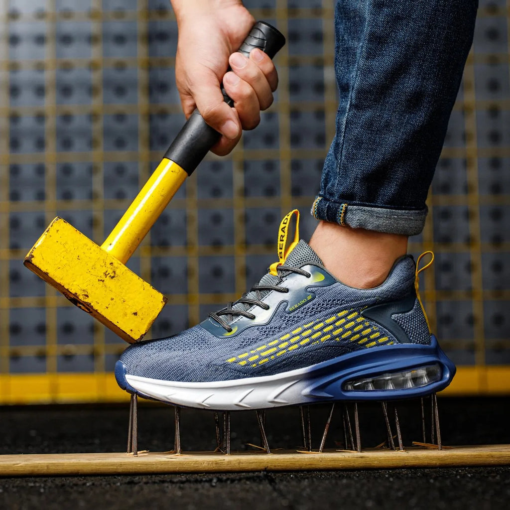 Blue trainer with yellow pull tab resting sole-up on a bed of nails while a mallet is held above it, demonstrating puncture resistance
