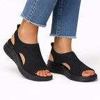 Black knit slingback sandal with open toe and cutout detail, shown on foot with black midsole and outsole.