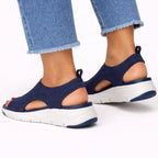 Rear three-quarter view of navy knit sandals showing heel pull tab, cutout sides and white ridged sole.