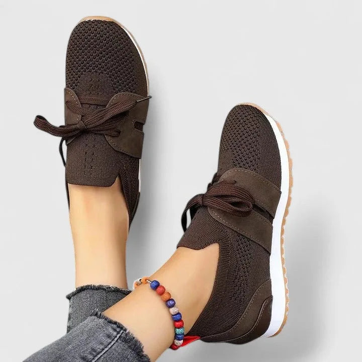 Brown knit trainers with suede-look overlay, bow laces and tan ridged outsole, worn with ankle bracelet