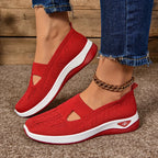 Red woven mesh trainers with triangular side cut-out and matching red and white sole, angled side view