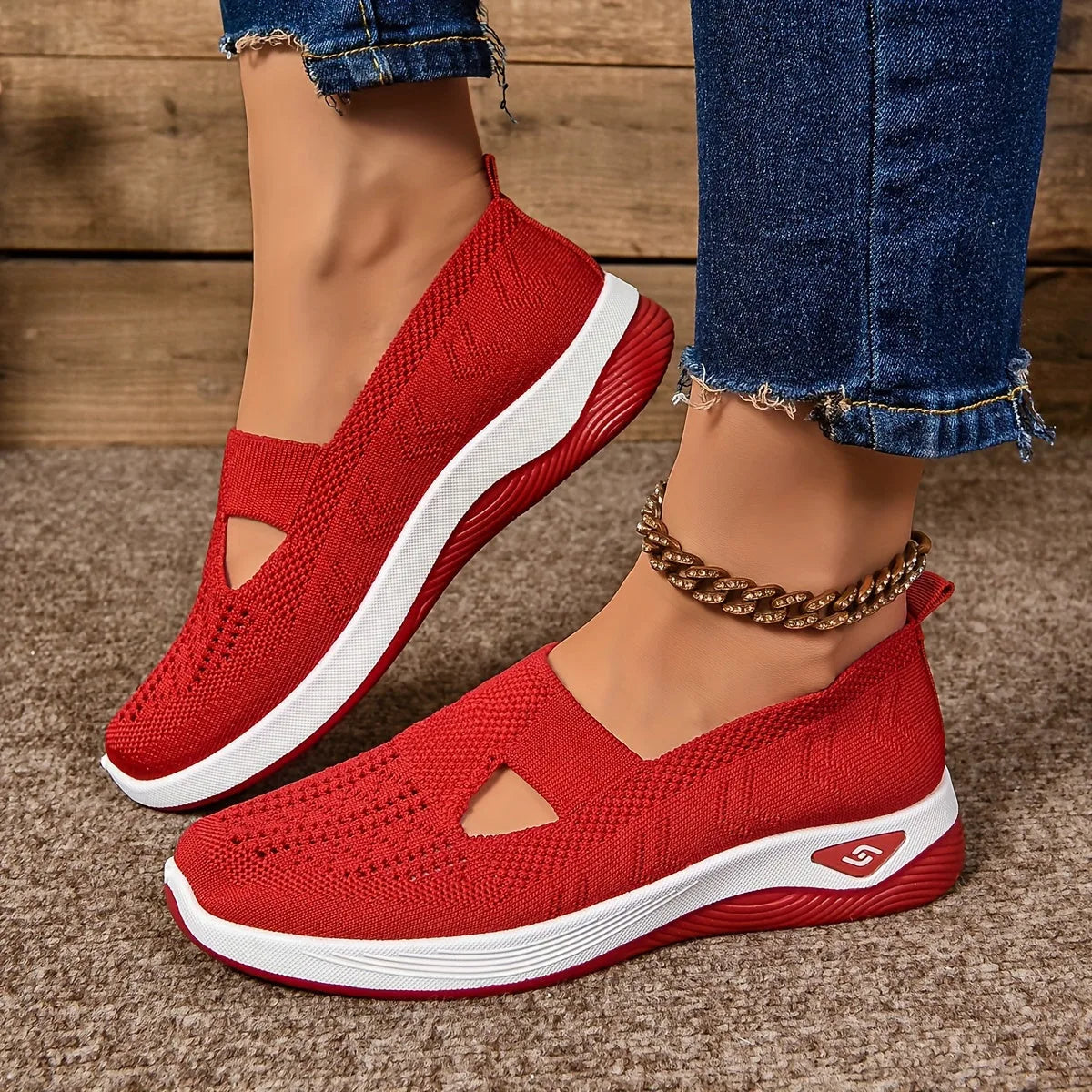 Red woven mesh trainers with triangular side cut-out and matching red and white sole, angled side view