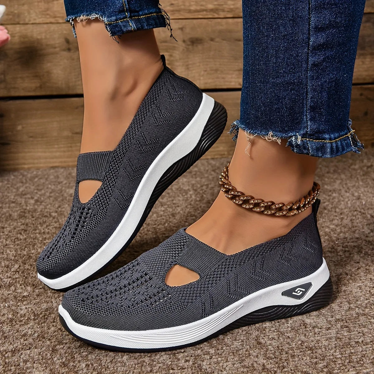Charcoal grey woven trainers with cut-out upper and black and white ridged sole, close side profile shot
