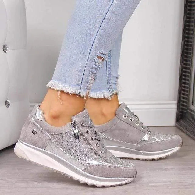 Front view of grey trainer showing silver zip pull, lace-up front and chunky white sole