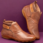 Side view of brown leather ankle boots showing stitched seams and pull tab detail