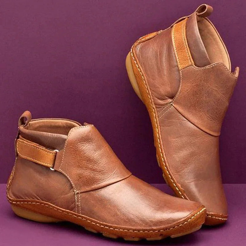 Side view of brown leather ankle boots showing stitched seams and pull tab detail
