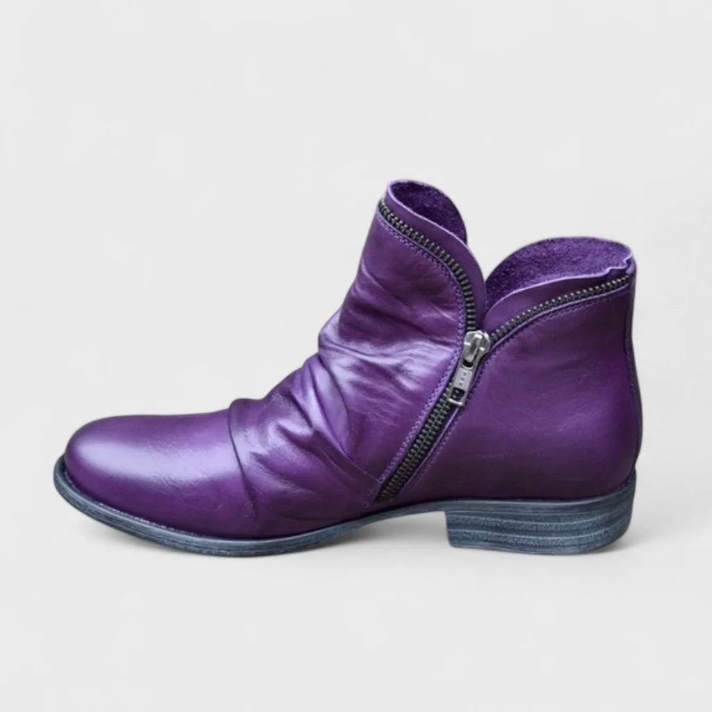 Side view of purple leather ankle boot with slouched shaft, side zip and stacked block heel