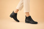 Side view of black leather ankle boots with side zip fastening and low block heel