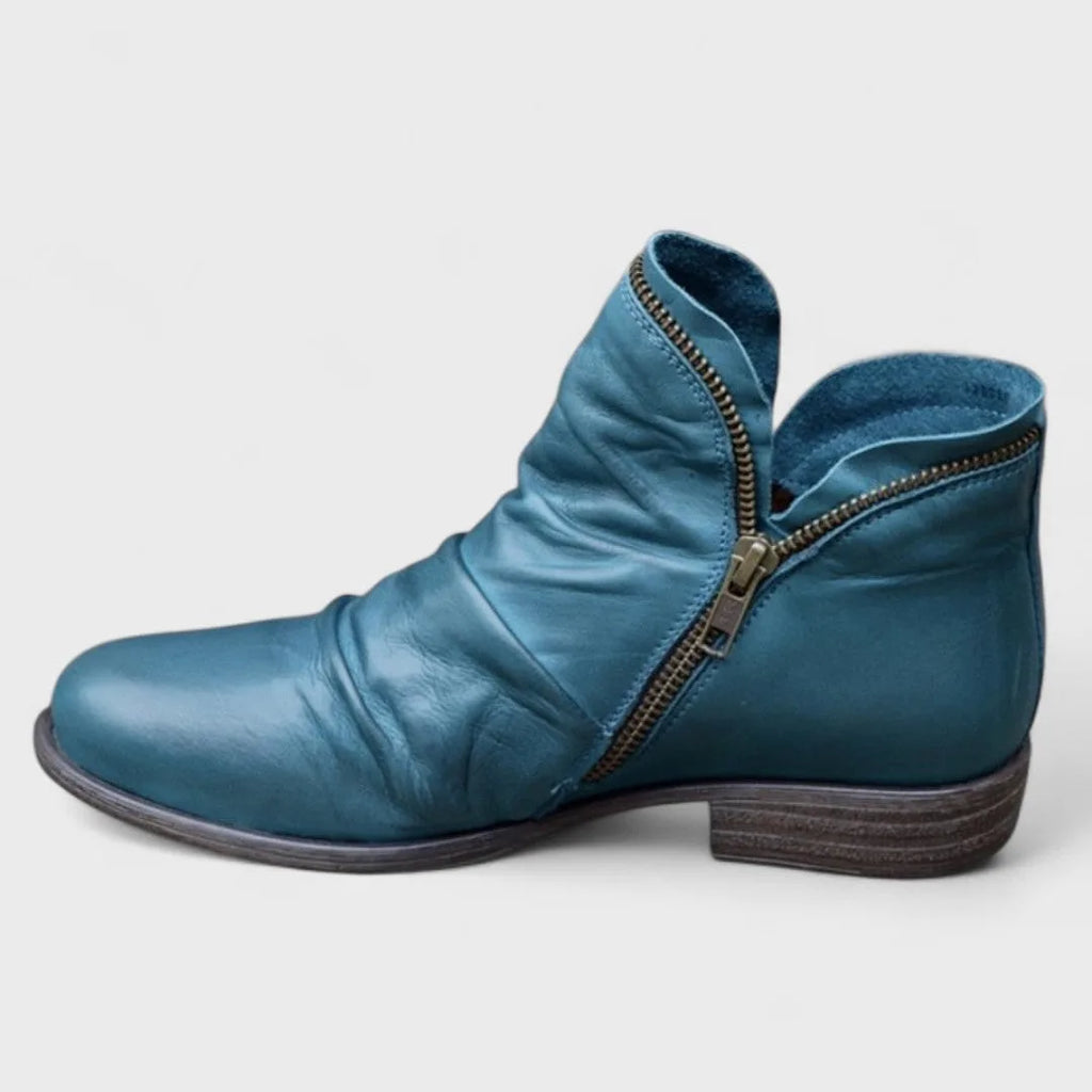 Teal blue leather ankle boot with brass side zip and folded cuff, stacked wooden-look heel