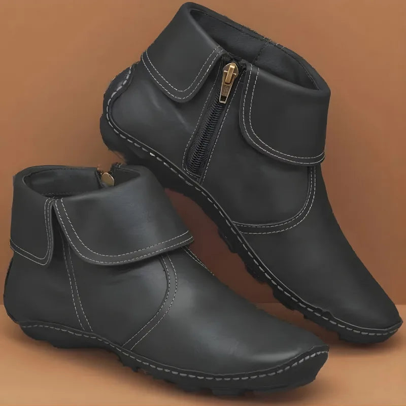 Black leather ankle boots with foldover top, brass-tone zip pull and ridged non-slip sole