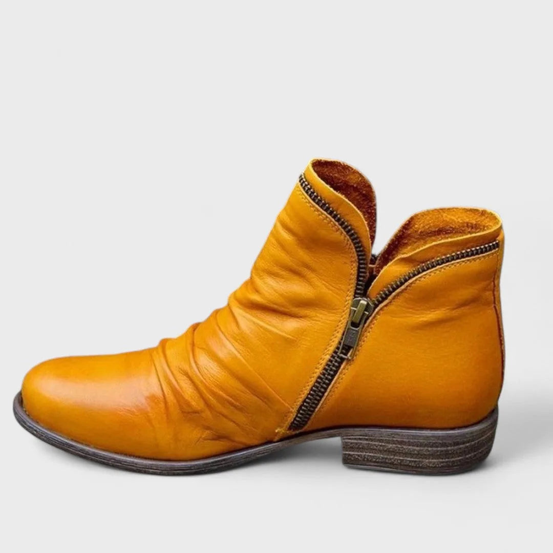 Mustard yellow leather ankle boot with slouchy shaft and exposed brass zip detail