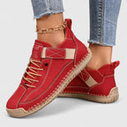 Red leather lace-up trainers with beige strap and hand-stitched trim, paired with cropped jeans