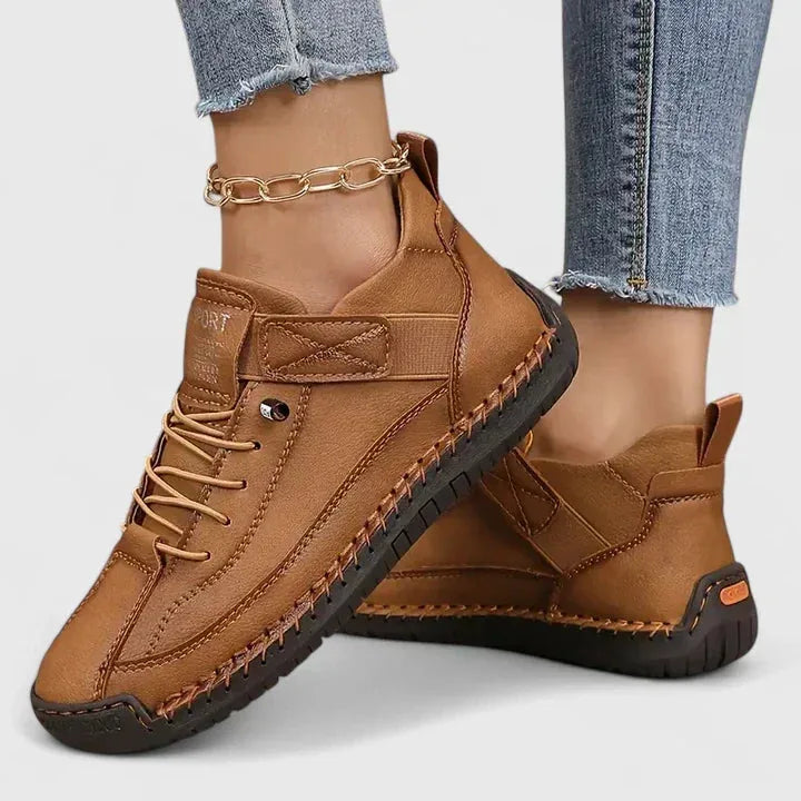 Tan brown leather lace-up trainers with contrast stitching and chunky sole, worn with cropped jeans