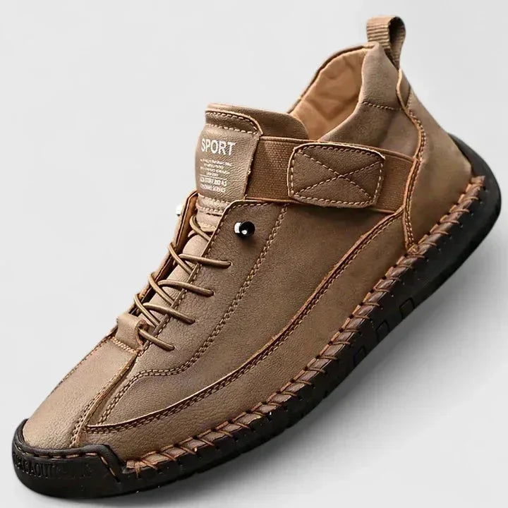 Close-up angle of the hand-stitched leather upper and ridged sole on a pair of comfort trainers