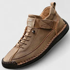 Close-up angle of the hand-stitched leather upper and ridged sole on a pair of comfort trainers