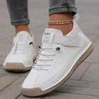 White leather trainer with contrast stitching and cream sole, worn with cropped grey jeans and a gold anklet
