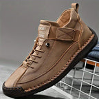 Pair of black trainers shown from the front with hand-stitched detailing along the toe and side panels